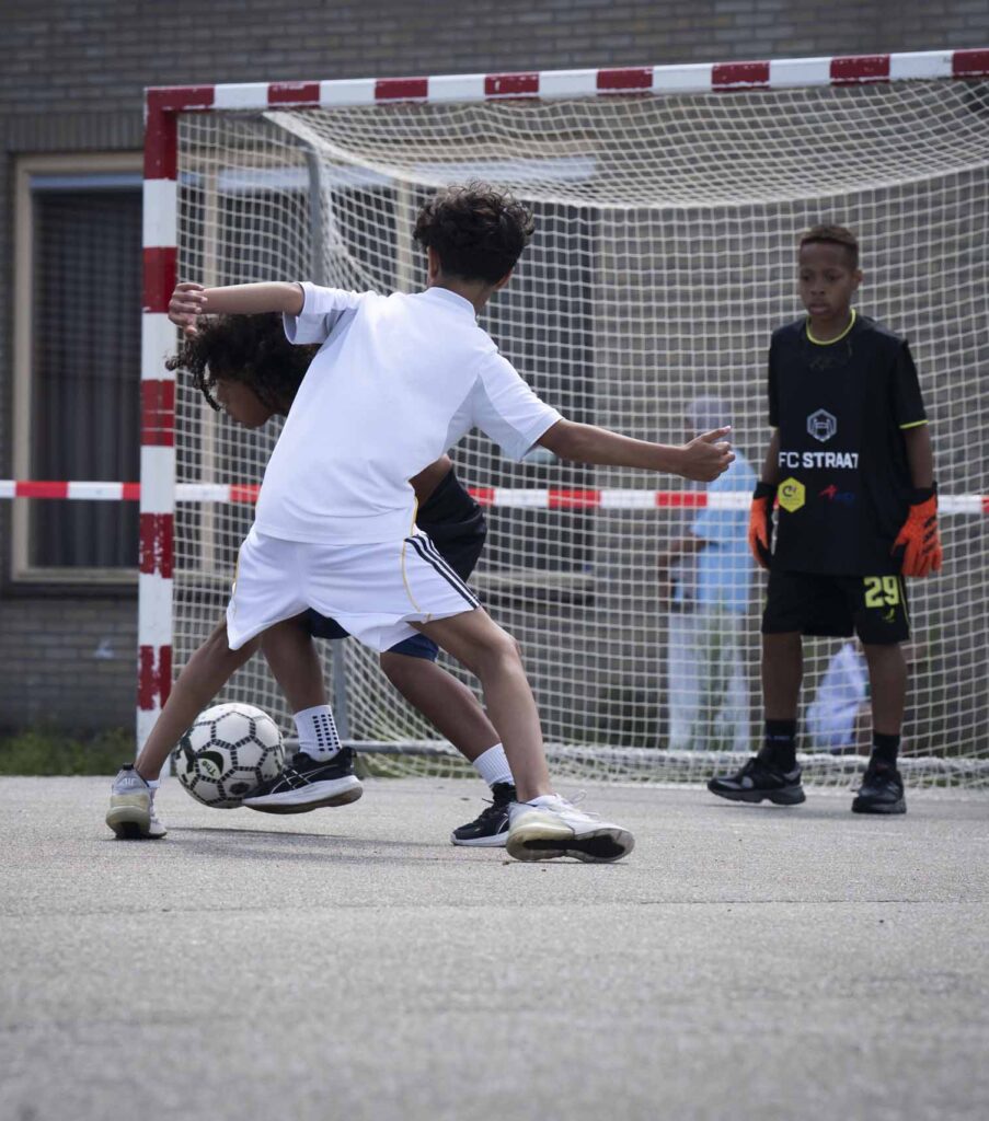Jongens die voetballen op straat