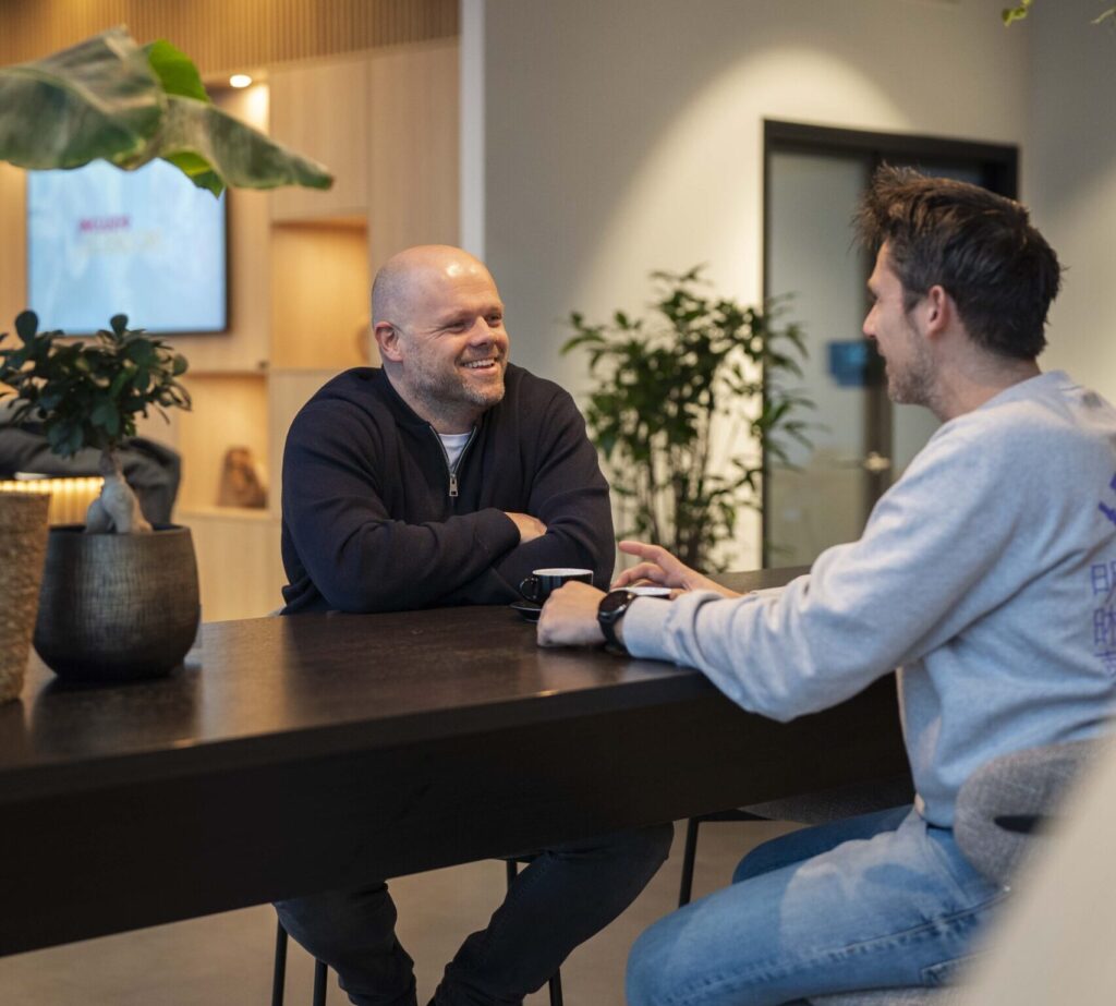 Twee mensen in gesprek aan een tafel
